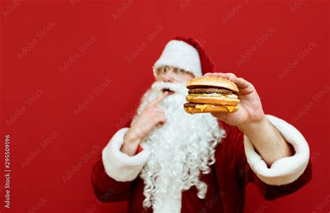 Delicious Big Burger Holds Santa Claus In His Hand And Wants To Eat