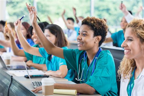 Medical School Students Raise Hands During Class Stock