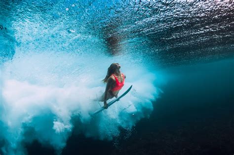 Surfer Woman With Surfboard Dive Underwater With Under Ocean Wave Stock