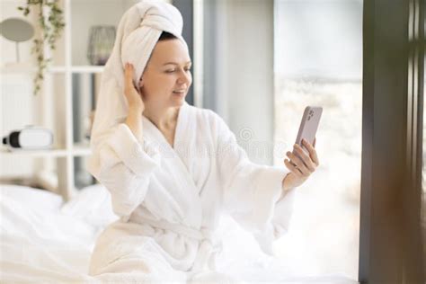 Adult Female Taking Selfie On Mobile While Sitting On Bed Stock Image