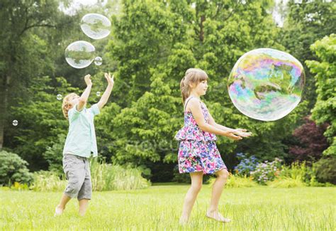 Niños Felices Jugando Con Burbujas Al Aire Libre — Vista Lateral