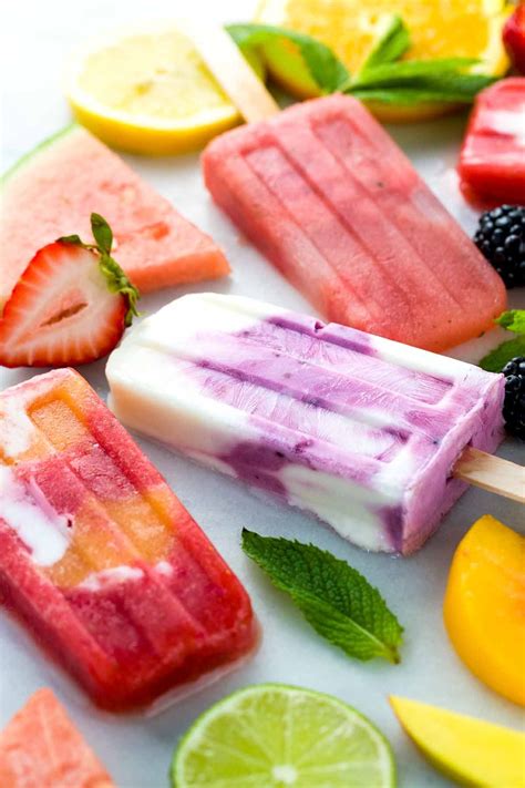 Popsicles With Fruit And Ice Cream Are Arranged On A White Surface Including Lemons