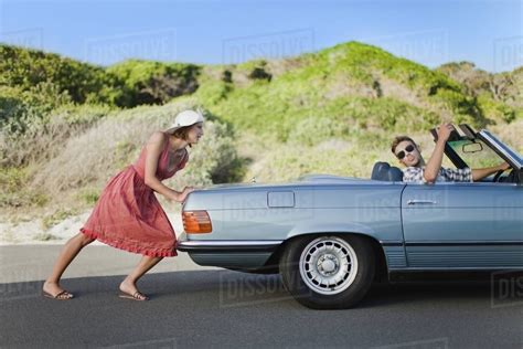 Woman Pushing Car As Boyfriend Steers Stock Photo Dissolve