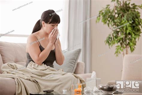 Sick Asian Woman Sitting On Sofa Blowing Her Nose Stock Photo Picture