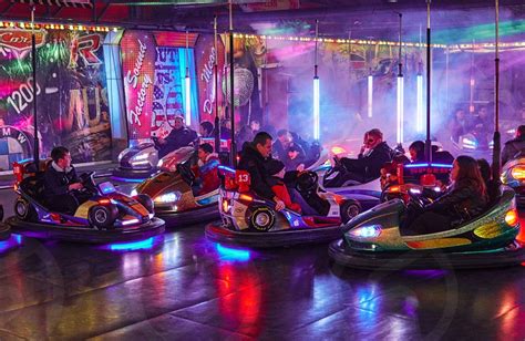 People In Bumper Cars Colorful Illuminated Amusement Park Ride Having Fun Traveling Carnival