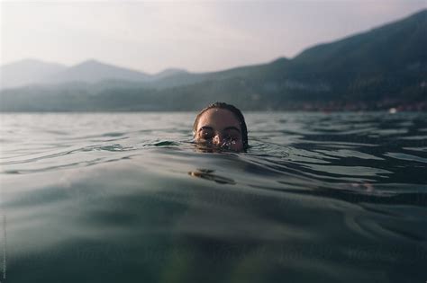 Woman Swimming In The Lake At Sunset By Michela Ravasio