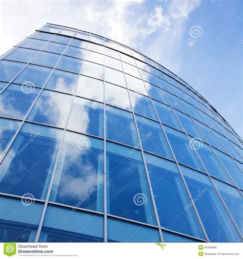 Curved Facade Of Modern Glass Blue Office And Clouds Royalty Free Stock