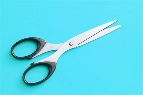 Free Image Of Pair Of Scissors Isolated On Cyan Background Freebie