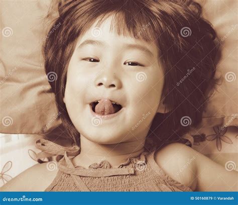cute little asian girl face while playing in the bed stock image