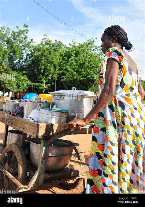A Burkinabe Woman Pushing Her Home Cooked Food Cart In Central