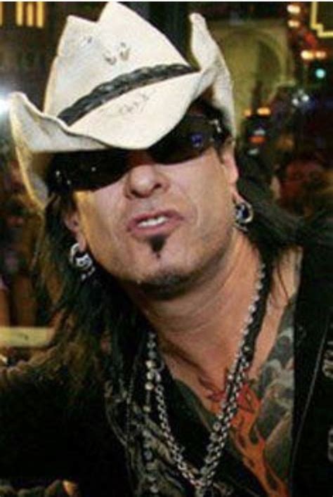 A Man With Long Hair Wearing A Cowboy Hat And Black Sunglasses Is