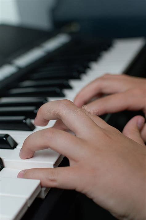Fingers Of A Child On The Piano Keyboard Close Up Vertical Stock