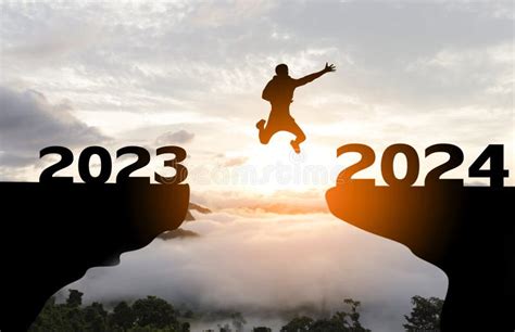 Abstract Silhouette Man Jump From 2023 To 2024 At Sunrise Stock Photo