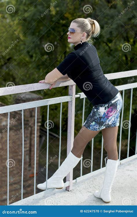 Die Sexy Frau In Den Weißen Stiefeln Und Ein Minirock Auf Der Brücke Schauen Stockfoto Bild