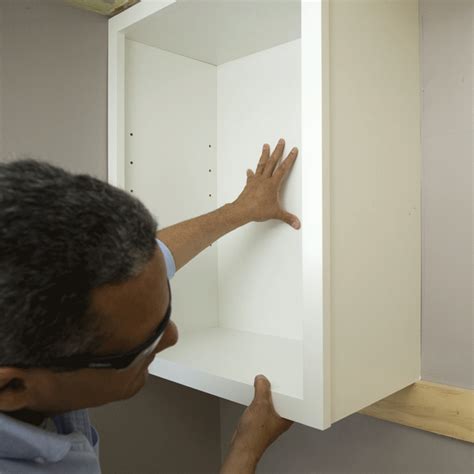 If its upper edge does not align with the horizontal line you made on the wall earlier, shim the base of the. setting the cabinet in place on the wall, resting it on ...