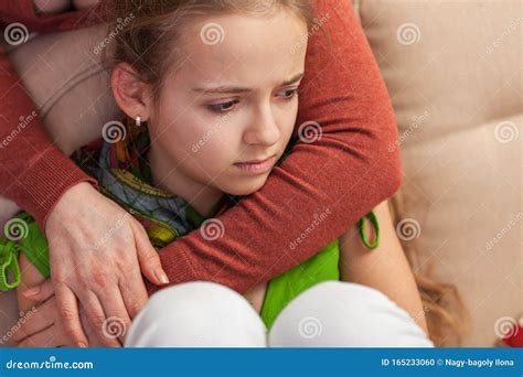 Worried And Sad Young Girl Sitting On Sofa Woman Embracing And