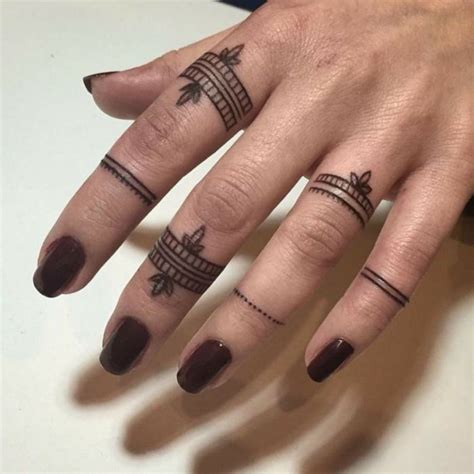 tatuajes en los dedos mujer con uñas en carmín dedos con tatuajes negros de anillo diferente