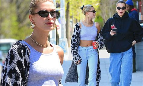 hailey baldwin flashes taut midriff as bff bella hadid keeps covered in baggy ensemble out in