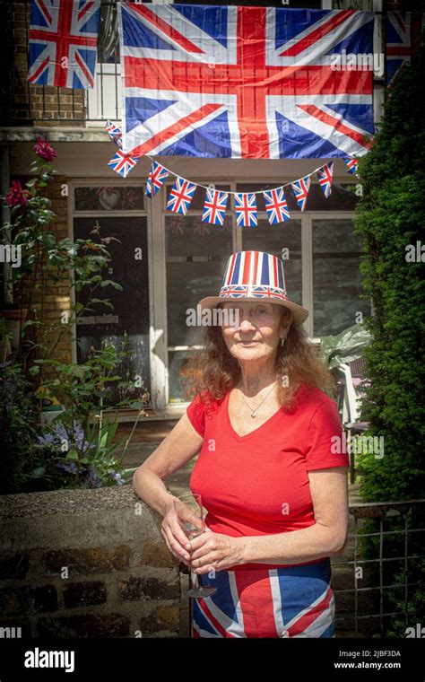 Woman In Front Of Union Jack Flags And Bunting Outside A Council House