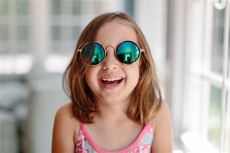 Cute Young Girl With Sunglasses Laughing By Jakob Lagerstedt