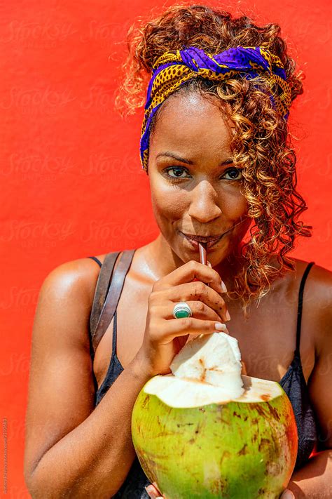 woman drinking coconut by stocksy contributor andrey pavlov stocksy