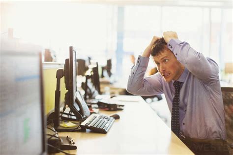 Stressed Businessman Pulling His Hair Out At Computer In Office Stock Photo