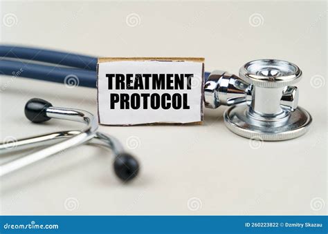On A Gray Background A Stethoscope And A Cardboard Sign With The