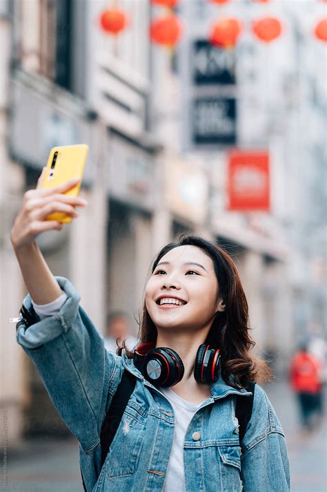 Young Chinese Girl Taking Selfie In Street By Stocksy Contributor Maahoo Stocksy