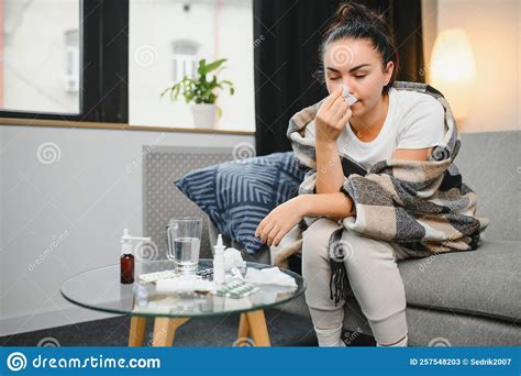 Ill Young Woman Sit On Sofa Covered With Blanket Freezing Blowing Her