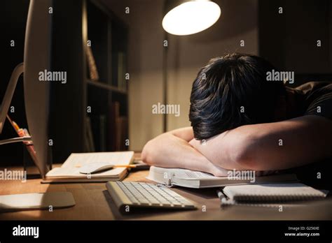 Exhausted Overworked Young Man Studying And Sleeping On The Table In