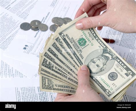 Closeup Of Female Hands Counting Tax Money Over W 9 Income Tax Forms