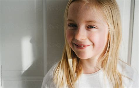 A Sunlit Little Girl Looking At Camera And Smiling By Stocksy