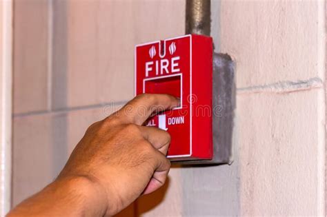 Hand Pulling Down The Manual Fire Alarm Station In Case Of Fire