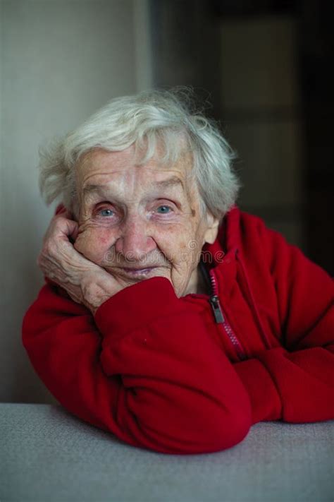 Old Happy Lady Woman In Her House A Portrait Sitting At A Table In A