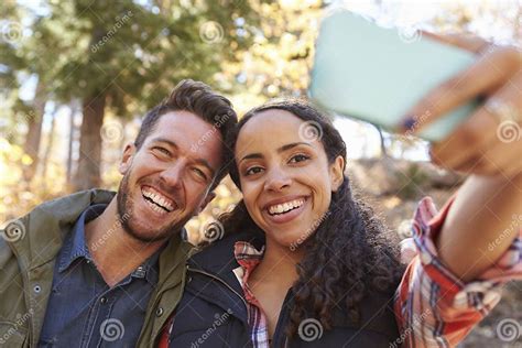 Laughing Mixed Race Couple Taking A Selfie In A Forest Stock Image Image Of Communication