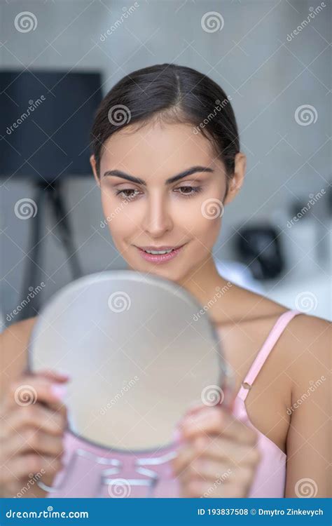 Pretty Woman In Pink Lingerie Holding A Round Mirror Stock Photo