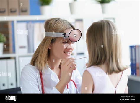 Childrens Otorhinolaryngologist Examines The Girls Throat Stock Photo