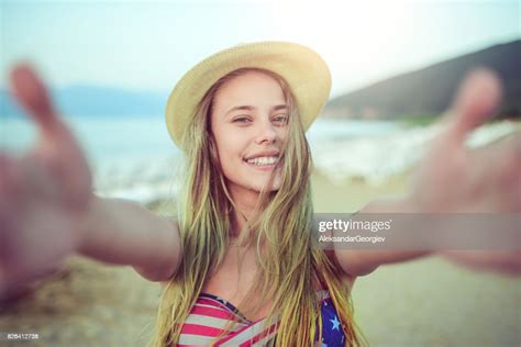 Young Teenage Girl With Straw Hat Taking Selfie On Beach In Summer High