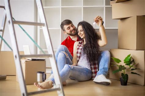 Happy Young Couple Moving In New Home Unpacking Boxes Stock Photo