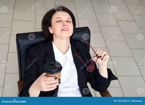 Business Woman Sitting Relaxed On A Chair Leaning Back With Closed Eyes