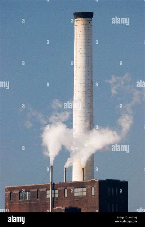 A Tall Smokestack Rises Above A Brick Factory Building Stock Photo Alamy