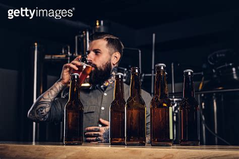 Photo With Craft Beer Bottles On The Foreground And Bearded Male