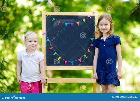 Zwei Regten Kleine Schwestern Durch Eine Tafel Auf Stockfoto Bild Von Vorstand Kind 42186758