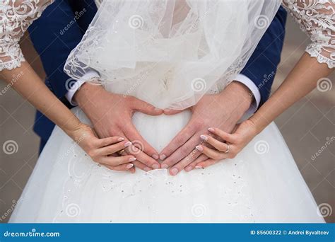 Bride And Groom Holding Their Hands In A Heart Shape Stock Photo