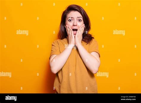 Portrait Of Terrified Person Holding Hands On Face To Pose On Camera Scared Woman Screaming And