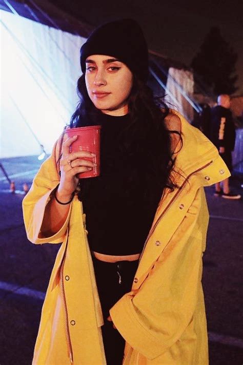 A Woman In A Yellow Jacket Holding A Red Cup
