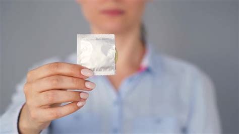 Female Hands Demonstrating Condom Before Camera Safe Sex