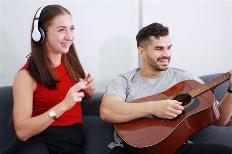 Smiling Caucasian Couple Love Happy Together In Living Room Handsome Husband Playing A Guitar