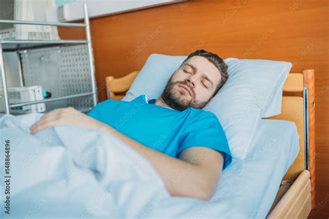 Young Sick Man Sleeping On Hospital Bed At Ward Hospital Patient Bed