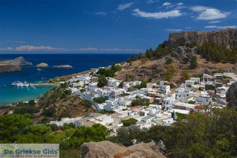 Solen går ned over de hvide huse i den idylliske by lindos. 10 redenen om op vakantie naar Rhodos te gaan!